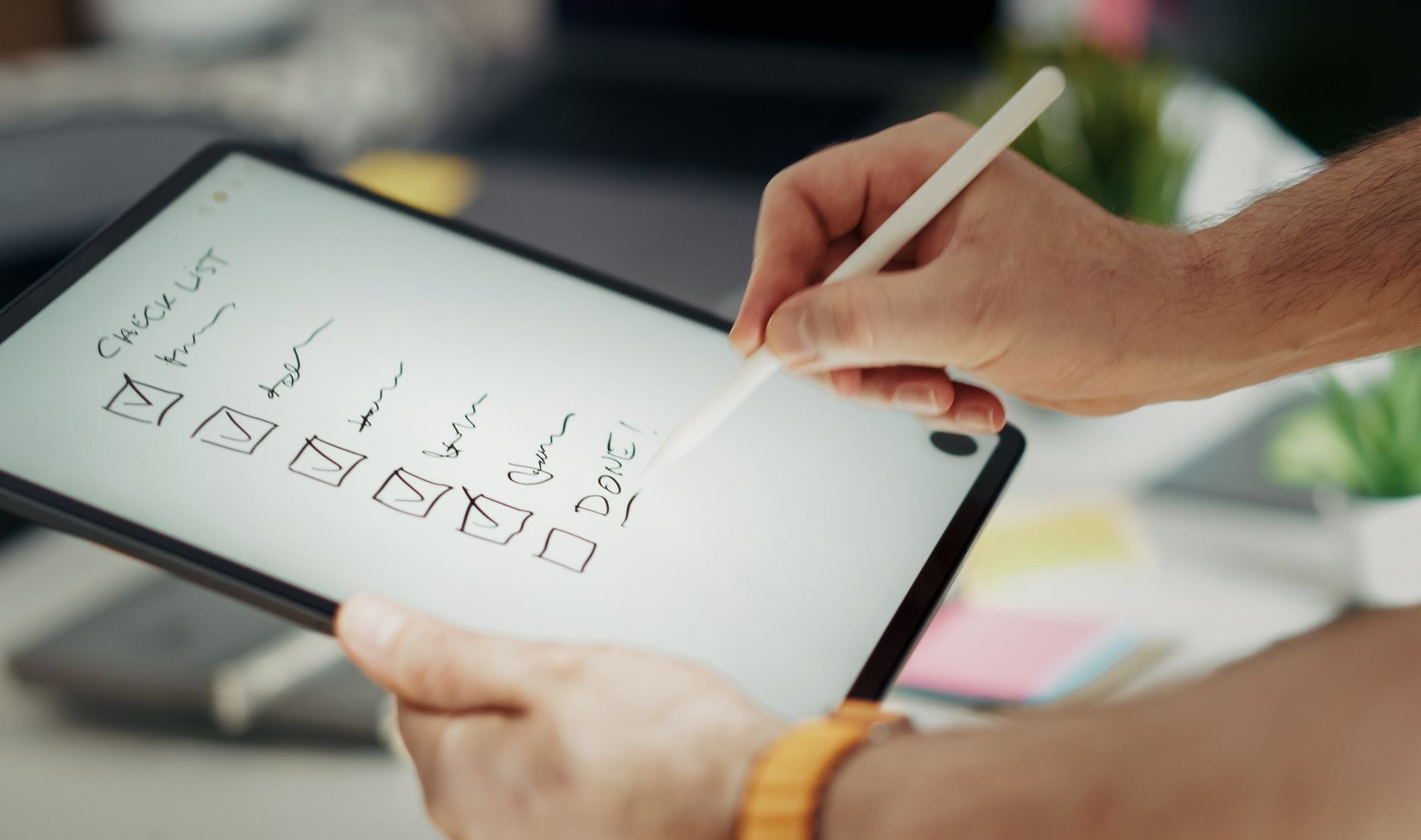 A hand checks off the last item on a tablet checklist.